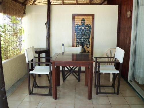 波拉波拉特曼努阿塔乡村酒店的餐桌和椅子,墙上有绘画作品