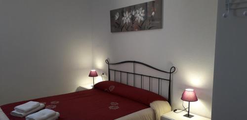奥尔塔-德圣胡安Font Major的一间卧室配有一张红色的床和两盏灯