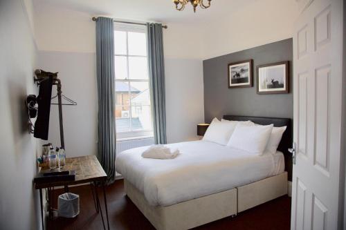 拉姆西The Mortimer Arms的卧室配有白色的床和窗户。