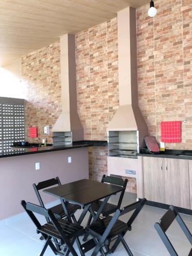 伊瓜苏普萨达萨尔瓦多尚黛酒店的厨房配有桌子和四把椅子