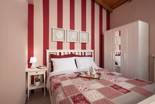 塔伦蒂斯Stefanos House的一间卧室配有一张红色和白色条纹的床
