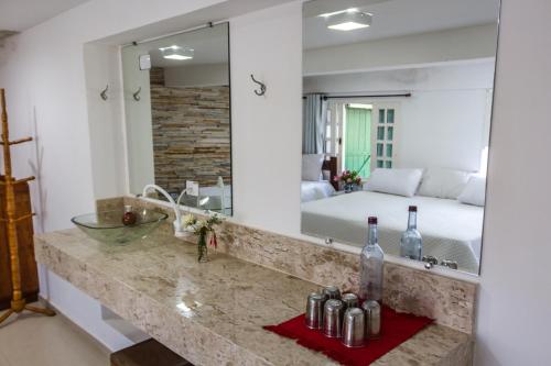 帕赖索波利斯Pousada Paraiso do Alto的一间带水槽、床和镜子的浴室