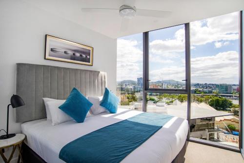 布里斯班Brisbane One Apartments by CLLIX的一间卧室设有一张大床和大窗户