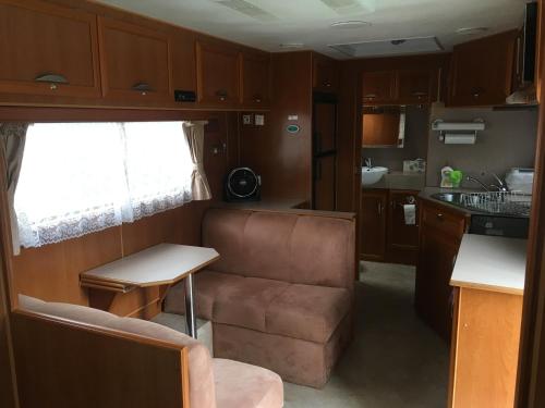 库克敦Comfortable caravan的带沙发的客厅和厨房