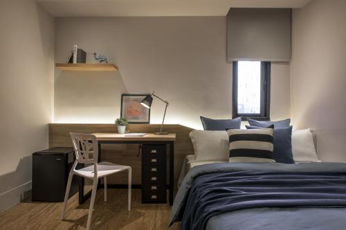 彰化市H suite Go的一间卧室配有一张床和一张桌子及椅子