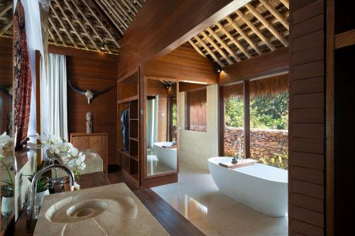 WatukarereLelewatu Resort Sumba的浴室配有2个盥洗盆、浴缸和浴缸。