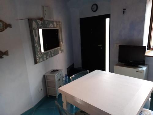 吉廖港Isola del Giglio的一间设有白色桌子、电视和窗户的客房