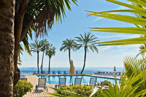 伊利塔斯Palace Bonanza Playa Resort & SPA by Olivia Hotels Collection的一个带椅子和棕榈树的游泳池以及大海