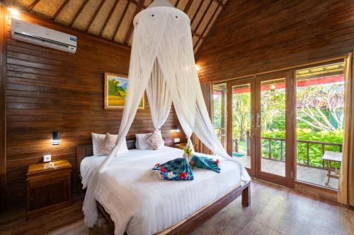 蓝梦岛Taos House Nusa Lembongan by Best Deals Asia Hospitality的一间卧室配有一张带蚊帐的床