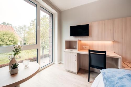 OvelgönneGasthaus Großenmeer的一间卧室配有书桌和桌椅