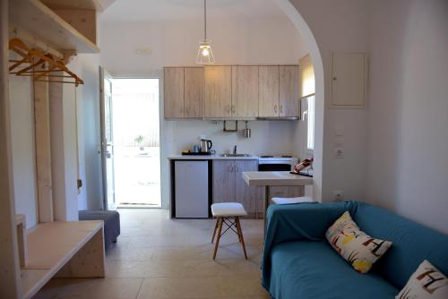 克洛瓦斯米科诺斯岛弗洛拉公寓的一间带蓝色沙发的客厅和一间厨房