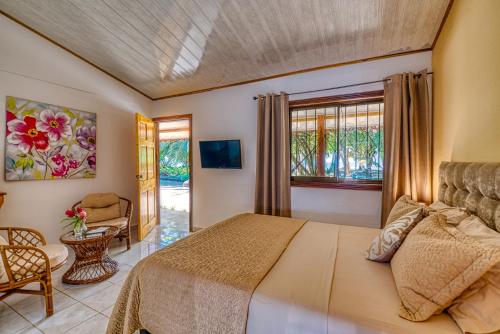 别霍港Yucca Beachfront Hotel的卧室配有床、椅子和窗户。