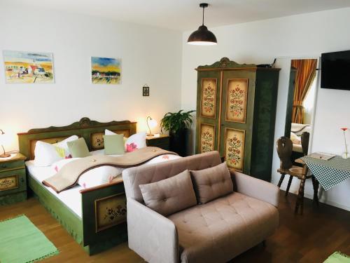 梅尔克玛丽兰霍夫住宿加早餐旅馆的一间卧室配有一张床、一张沙发和一把椅子