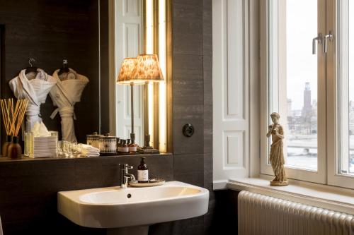 斯德哥尔摩利德玛酒店的一间带水槽和镜子的浴室以及窗户。