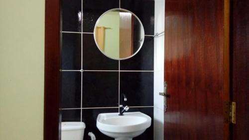 Barra do CamaragibePousada Tiriri Guesthouse的浴室设有水槽和墙上的镜子