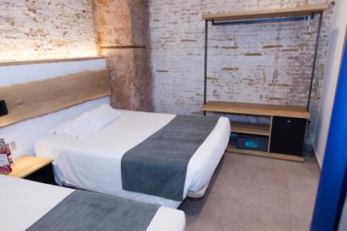 巴塞罗那巴黎旅馆的酒店客房设有两张床和窗户。