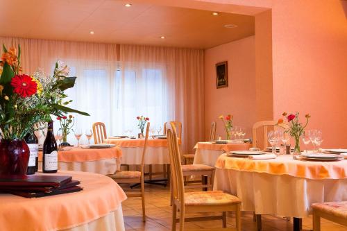 吕兹-圣索沃尔勒蒙太古酒店的用餐室配有桌椅和鲜花