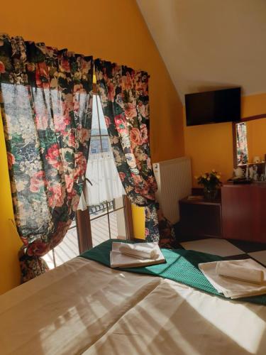 鲁达希隆斯卡Malinowy Dwór的一间卧室配有一张床,窗户配有窗帘