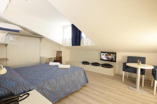 利多迪耶索罗塞雷内拉酒店的一间卧室配有一张床、一张桌子和一台电视。