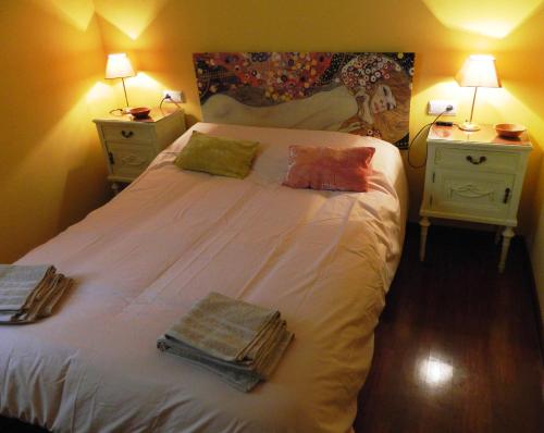 格拉纳达Escapadas romanticas en Granada jacuzzi的一间卧室配有一张带2个床头柜的大型白色床