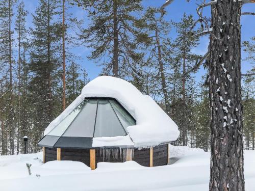 KakslauttanenHoliday Home Arctic light hut by Interhome的森林中间的雪覆盖的天文台