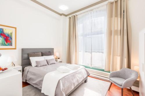 魁北克市Condo Le 1000 - Quebec的卧室配有床、椅子和窗户。