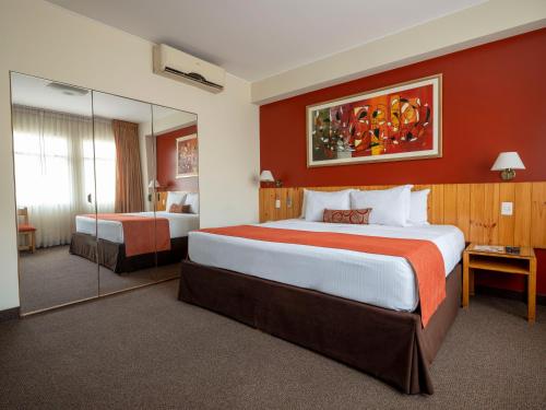 利马库里安卡酒店的配有一张大床和镜子的酒店客房