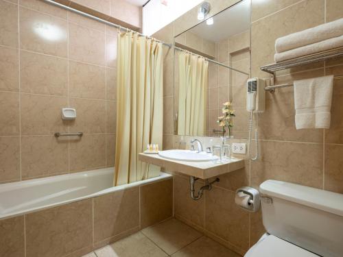 利马库里安卡酒店的一间带水槽、浴缸和卫生间的浴室