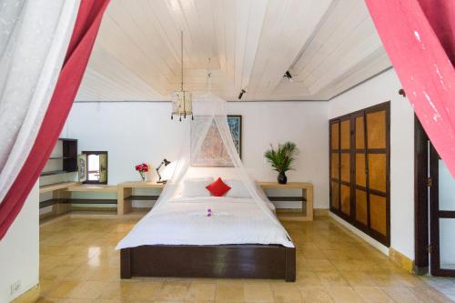 克拉玛斯普里昂萨萨巴民宿的一间卧室配有一张带蚊帐的床