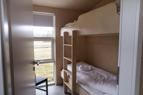 劳加尔埃尼休斯小屋酒店的一间小卧室,配有双层床和窗户