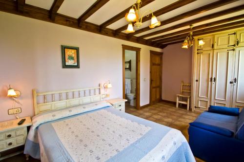 圣维森特-德拉巴尔克拉Hospedaje Granada的一间卧室配有一张大床和一张蓝色的沙发
