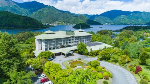 富士河口湖富士豪景酒店的享有湖景和山景的建筑的空中景致