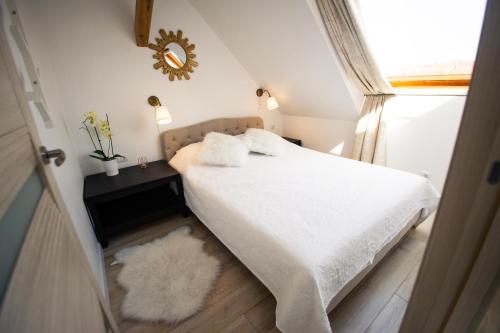 奈达Apartamentai Niden - su terasa ir vaizdu i marias Nidos centre的一间卧室配有一张带白色床单和镜子的床