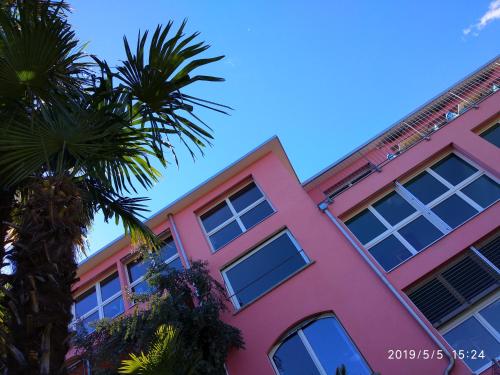 布里萨戈维纳斯瑞斯顿斯花园旅馆的前面有棕榈树的粉红色建筑