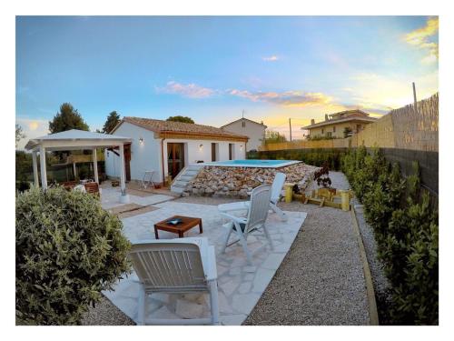 罗卡圣焦万尼Il Giardino Di Epicuro的一个带白色椅子的庭院和一个游泳池