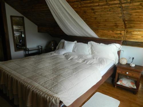 Sadu浪漫佩秀尼亚酒店的卧室内的一张大床,拥有木制天花板