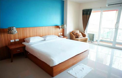 芭堤雅市中心D Apartment的一间卧室设有一张蓝色墙壁的大床