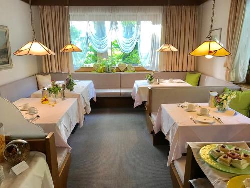 拉纳Hotel Burgleitenhof的一间设有四张桌子和窗户的用餐室
