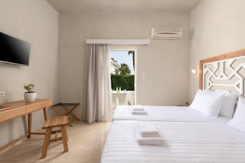 普拉基亚斯普拉基亚斯阿波罗酒店的一间卧室配有两张床、一张桌子和一台电视。