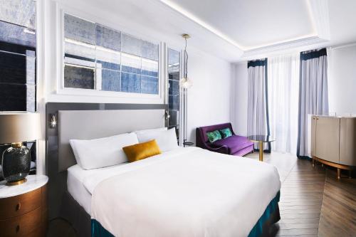 索非亚Sofia Balkan Palace的酒店客房配有白色的床和紫色椅子