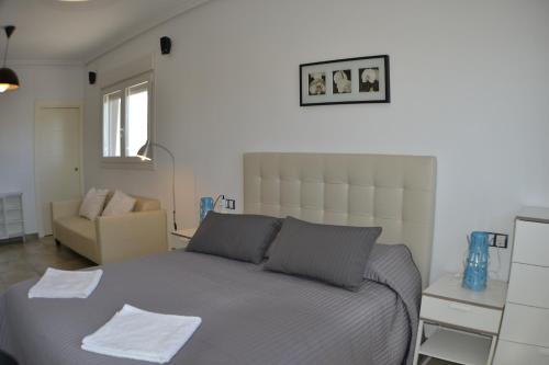 厄尔·波索·德·洛斯·弗莱尔卡萨斯玛丽亚卡莫纳度假屋的一间卧室配有一张床和一张沙发