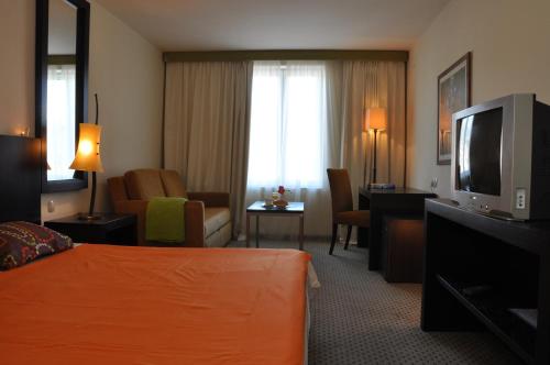 拉布国际酒店的配有一张床和一台平面电视的酒店客房