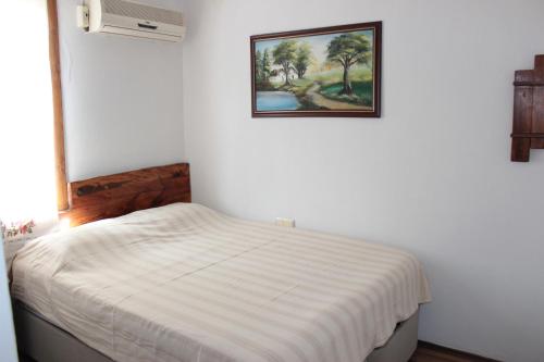塞尔丘克图恩凯旅馆的白色卧室配有一张挂着壁画的床