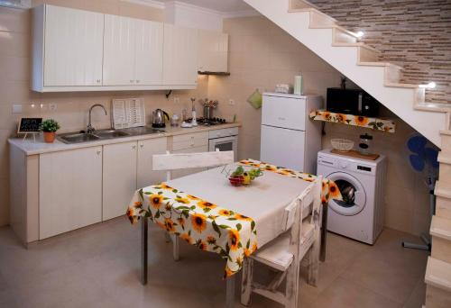 库巴A Casa dos Girassóis的厨房配有桌子和洗衣机。