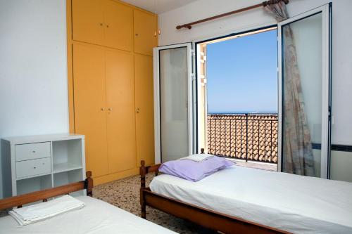 帕莱欧卡斯提撒Family House in Lakones的一间卧室设有两张床和大窗户