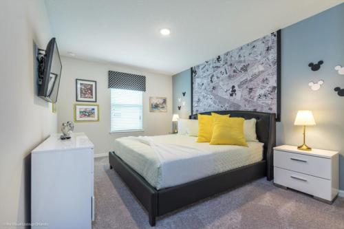 奥兰多Orlando Newest Resort Community Town Home Townhouse的一间卧室配有一张带黄色枕头的床和一台电视。