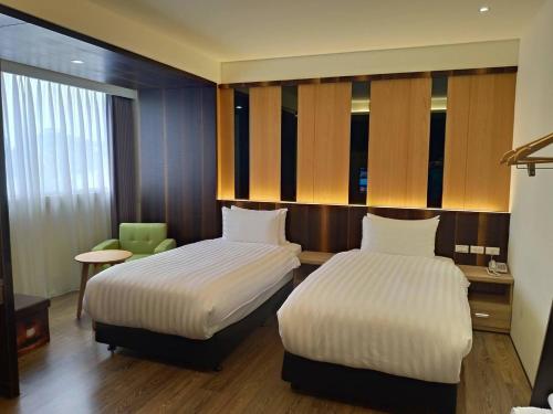 嘉义市兰潭泛月文旅的酒店客房,配有两张床和椅子