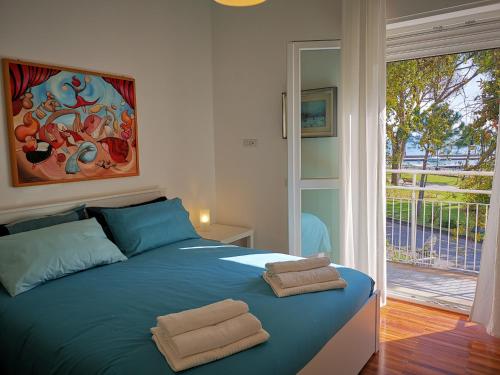 博尔塞纳Villa Clara的一间卧室配有蓝色的床和2条毛巾