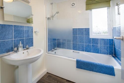 贝灵汉姆Brown Rigg Lodges的浴室配有白色浴缸、盥洗盆和浴缸。