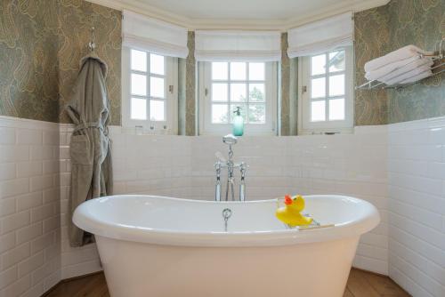 德哈恩Romantik B&B Zonnehuis的浴室内设有带橡皮鸭的浴缸